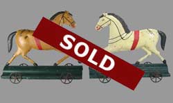 pair of tin horses on wheels