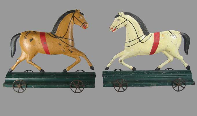 pair of tin horses on wheels