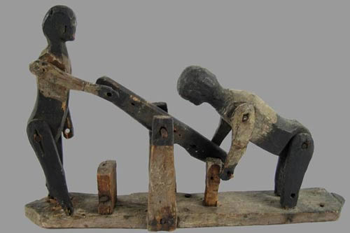 primitive wooden men on hand car